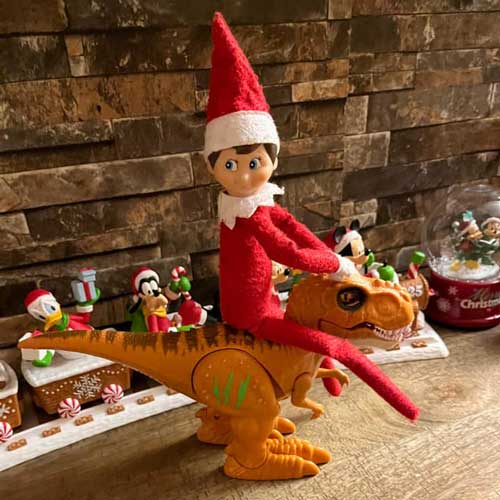 elf on the shelf riding dinosaur
